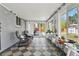 Sunroom with checkered tile, grey chairs and views of backyard is great for relaxing and entertaining at 3002 S Fenton St, Denver, CO 80227