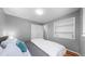 Bright bedroom with a full-size bed, white bedding and windows to bring in natural light at 1720 Mable Ave, Denver, CO 80229