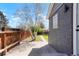 Private backyard featuring new fence, gray painted brick, mature birch tree and concrete patio at 4320 Lamar St, Wheat Ridge, CO 80033