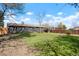 Green backyard featuring single story gray house with wood privacy fence in background at 4320 Lamar St, Wheat Ridge, CO 80033