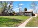 Spacious backyard with grass and a gray single story home with fenced perimeter at 4320 Lamar St, Wheat Ridge, CO 80033