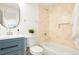Cozy bathroom featuring a blue vanity, bathtub with tiled walls and shower, complemented by modern fixtures at 4320 Lamar St, Wheat Ridge, CO 80033