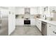 Beautiful kitchen featuring stainless steel appliances, white cabinetry, and stylish hexagonal tile flooring at 4320 Lamar St, Wheat Ridge, CO 80033