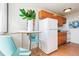 Cozy kitchen featuring wooden cabinets, white appliances, and a small dining table with modern chairs at 1196 N Grant St # 405, Denver, CO 80203