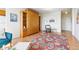 Open-concept living area with a Murphy bed, chair and a bright, patterned area rug at 1196 N Grant St # 405, Denver, CO 80203