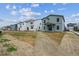 Rear view of modern two story homes with back patios and yards at 2177 Flower Blossom Ave, Brighton, CO 80601