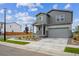 Modern two-story home with gray siding, a covered porch, and attached garage at 2177 Flower Blossom Ave, Brighton, CO 80601