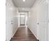 Long hallway with white walls and wood floors leading to the front door at 2177 Flower Blossom Ave, Brighton, CO 80601
