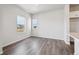 Living space with hardwood floors and two windows looking out to the neighborhood at 2177 Flower Blossom Ave, Brighton, CO 80601