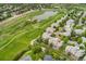 Aerial view showcases homes in a community bordering a golf course with a lake and trees at 9441 Southern Hills Cir, Lone Tree, CO 80124