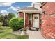 Inviting front entrance with red brick, a wreath, and decorative potted plants at 9441 Southern Hills Cir, Lone Tree, CO 80124