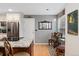 Well-lit kitchen and dining area with white cabinets, granite countertops, and stainless steel appliances at 9441 Southern Hills Cir, Lone Tree, CO 80124