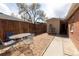 Private backyard area with a patio set, wooden fence, and access to an additional outdoor structure at 3021 Grape St, Denver, CO 80207