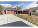 Spacious backyard featuring a brick home, concrete patio, basketball hoop, and covered area for outdoor activities at 3021 Grape St, Denver, CO 80207