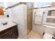 Well-lit bathroom featuring marble-style tiled walls and a glass-enclosed shower at 3021 Grape St, Denver, CO 80207