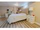 Charming bedroom with a queen-size bed, vanity, and wood-look laminate flooring at 3021 Grape St, Denver, CO 80207
