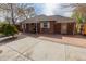 Charming brick home featuring a spacious front patio and well-manicured yard at 3021 Grape St, Denver, CO 80207