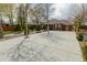 A well-kept lawn surrounded by manicured trees and a concrete driveway in front of a brick house at 3021 Grape St, Denver, CO 80207