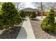 Landscaped front yard with gravel, mature trees, and a concrete path to the home at 3021 Grape St, Denver, CO 80207