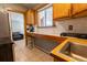 Kitchen featuring breakfast bar, tile countertops and wooden cabinets at 3021 Grape St, Denver, CO 80207