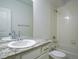 Bright bathroom featuring a granite countertop, white cabinets, and a shower over tub at 11860 Sandcastle Ct, Parker, CO 80138