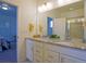 Bright bathroom with double sinks, granite countertops, white cabinets, and a glass enclosed shower at 11860 Sandcastle Ct, Parker, CO 80138