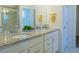 Bright bathroom with double sinks, granite countertops, white cabinets, and a glass enclosed shower at 11860 Sandcastle Ct, Parker, CO 80138