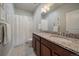 Bright bathroom features a dual sink vanity with granite countertop and shower-tub combination at 5663 W 96Th Ave, Westminster, CO 80020