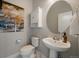 Stylish powder room with pedestal sink, round mirror, and decorative artwork at 5663 W 96Th Ave, Westminster, CO 80020