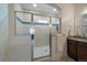 Walk-in shower with glass door, white tile, and blue accent at 5663 W 96Th Ave, Westminster, CO 80020