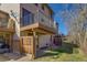 Cozy back patio with a small fence, balcony above, and grassy area beyond the patio at 1013 Homestake Dr # 17C, Golden, CO 80401