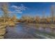 Picturesque view of Clear Creek flowing through a natural landscape with rocks and trees at 1013 Homestake Dr # 17C, Golden, CO 80401