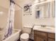 Cozy bathroom featuring a tub/shower and a light wood vanity with decorative mirrors at 3600 S Pierce St # 106, Lakewood, CO 80235