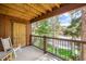 Comfortable balcony with a seating area and railing overlooks mature trees and the surrounding neighborhood at 180 Broken Lance Dr # 14, Breckenridge, CO 80424