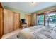 View of a cozy bedroom with wood accents, balcony, and two closets at 180 Broken Lance Dr # 14, Breckenridge, CO 80424