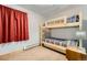 A cozy bedroom with carpet, a bunk bed, a window with red curtains, and a nightstand at 180 Broken Lance Dr # 14, Breckenridge, CO 80424