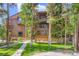 Multi-story home with wood siding and balconies, surrounded by lush greenery and a well-maintained lawn at 180 Broken Lance Dr # 14, Breckenridge, CO 80424