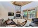 Cozy living room featuring a stone fireplace, wood ceiling, comfortable seating, and access to the balcony at 180 Broken Lance Dr # 14, Breckenridge, CO 80424