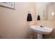 Cozy half bath featuring pedestal sink and decorative mirror at 4076 Andes Way, Denver, CO 80249