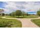 Expansive green space showcasing manicured lawns, walking paths, and mature trees under a partly cloudy sky at 4076 Andes Way, Denver, CO 80249