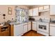 Bright kitchen with white cabinetry, modern appliances, and a window overlooking the yard at 4076 Andes Way, Denver, CO 80249