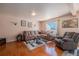 Cozy living room with hardwood floors, a large sofa set, and natural light from the window at 4076 Andes Way, Denver, CO 80249