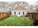 Spacious backyard with lush grass, landscaping, and a modern gray house with a private entry at 3005 Grove St, Denver, CO 80211