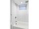 Modern bathroom featuring a bathtub, white tile walls, and updated fixtures at 3005 Grove St, Denver, CO 80211