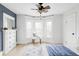 Bright bedroom featuring a ceiling fan, bay window with a chair, and a bed with blue blanket at 3005 Grove St, Denver, CO 80211