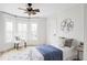 Bright bedroom featuring a ceiling fan, bay window with a chair, and a bed with blue blanket at 3005 Grove St, Denver, CO 80211