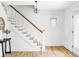 Bright foyer with hardwood floors, white staircase, and decorative lighting at 3005 Grove St, Denver, CO 80211