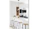Stylish kitchen featuring white cabinets, stainless steel appliances, and wooden bar stools at 3005 Grove St, Denver, CO 80211