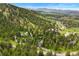 Scenic aerial shot showcases homes among the trees with mountain views in the background at 1129 Genesee Vista Rd, Golden, CO 80401
