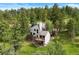 Aerial shot of house surrounded by trees showing decks and a well-manicured yard at 1129 Genesee Vista Rd, Golden, CO 80401